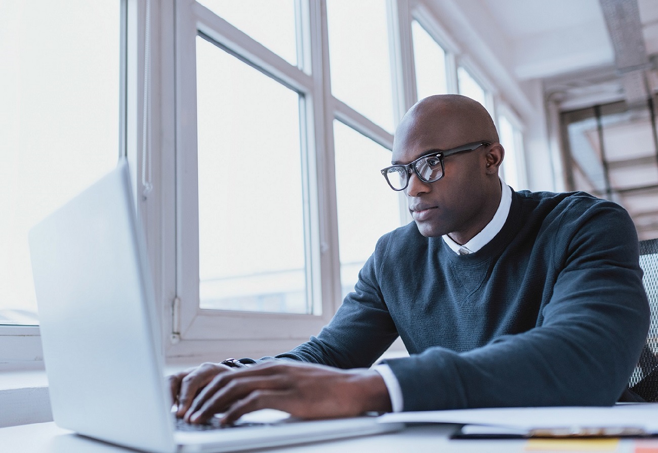 Mann mit einer Brille schaut in den Laptop