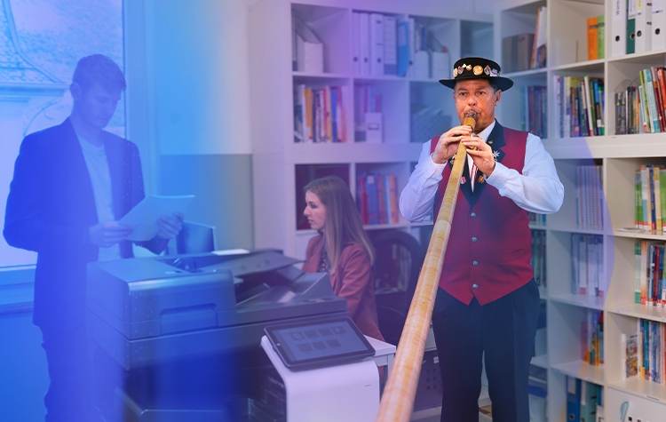 A person wearing glasses is looking at a laptop