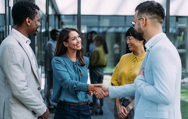 Eine Gruppe von vier und zwei Personen schütteln sich die Hand