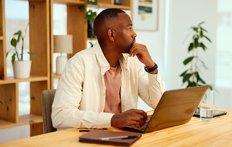 Ein Herr am Laptop überlegt