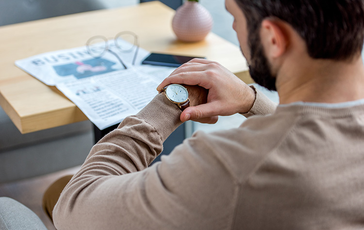 Ein Herr wirft einen Blick auf seine Uhr