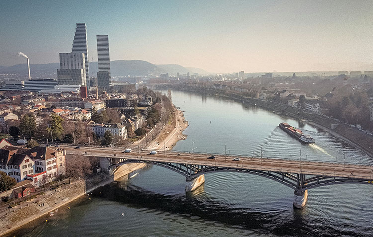 Eine Stadtaufnahme von Basel mit einem Fluss und Hochhäusern
