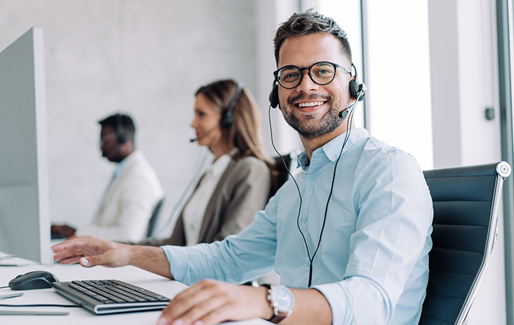 An advisor on the phone smiles at the camera