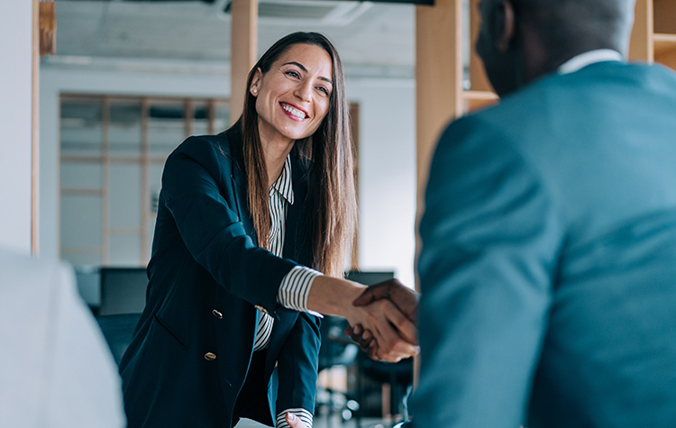 Eine Dame und ein Herr schütteln sich die Hand in einem Büro
