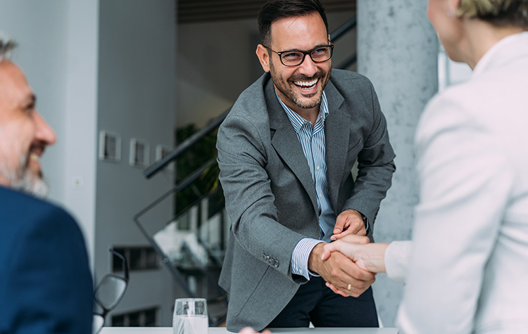 Zwei Personen schütteln sich die Hand in einem Büro