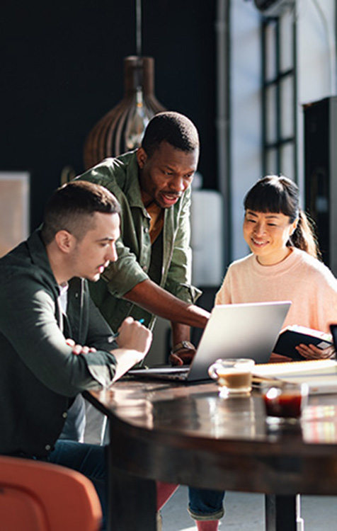 Un groupe de collègues regarde un ordinateur portable.