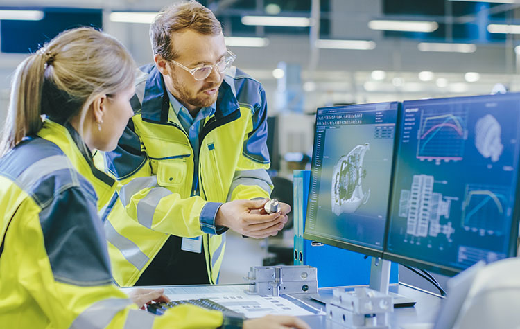 Zwei Ingenieure schauen am Computer ein 3D-Modell eines Bauteils an