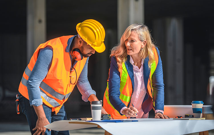 Zwei Bauexperten tauschen sich über einen Bauplan aus